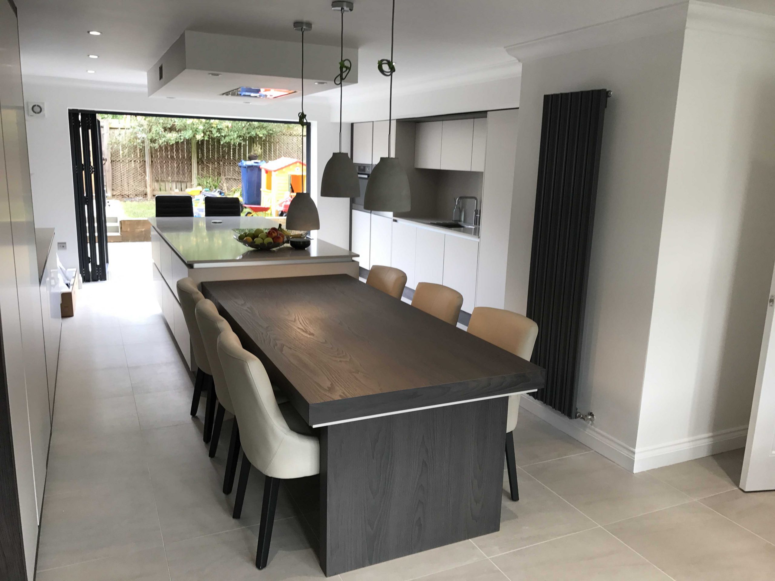 modern handleless kitchen featuring island with integrated dining