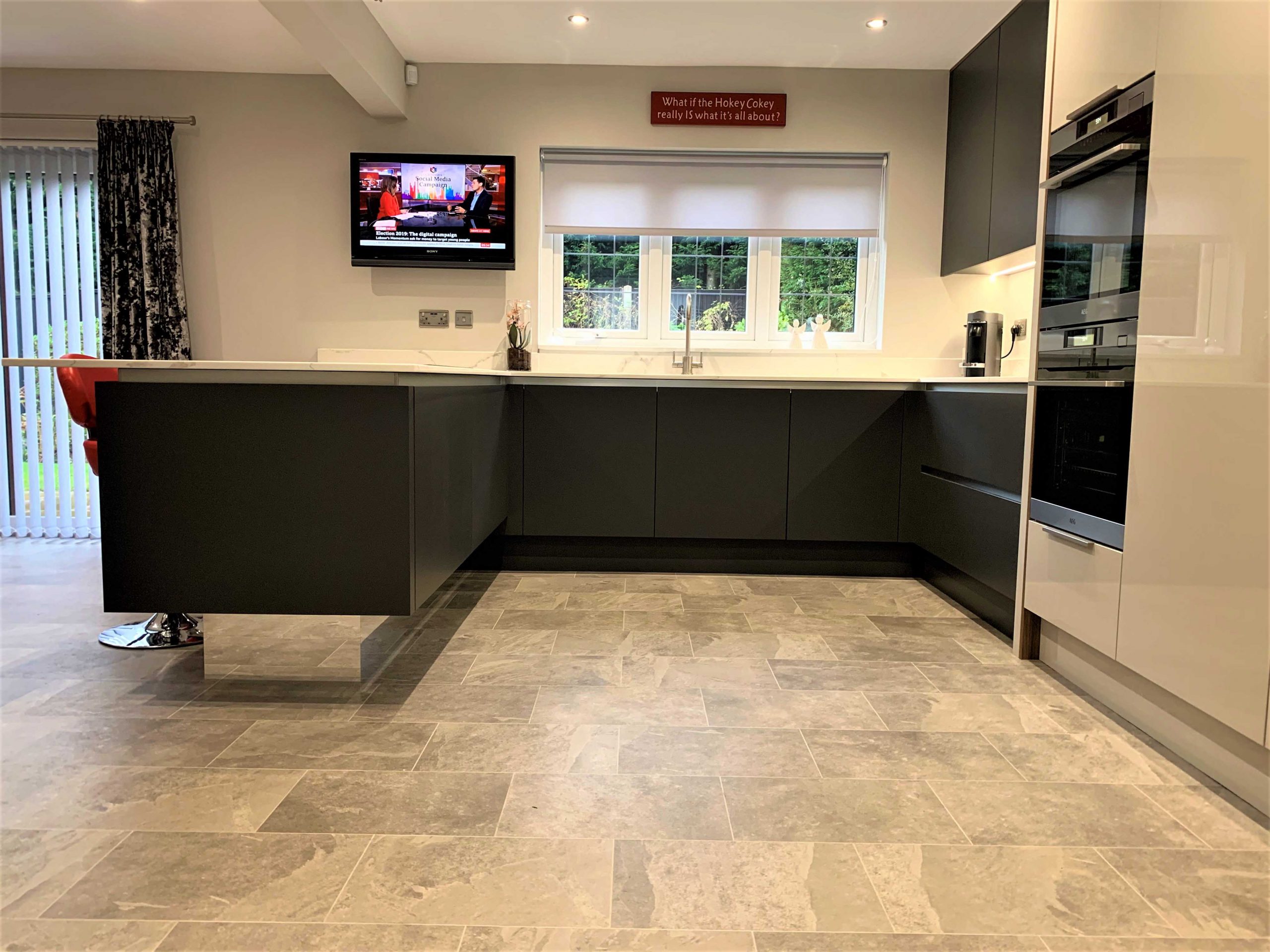 contemporary handleless kitchen with peninsular and hidden utility room