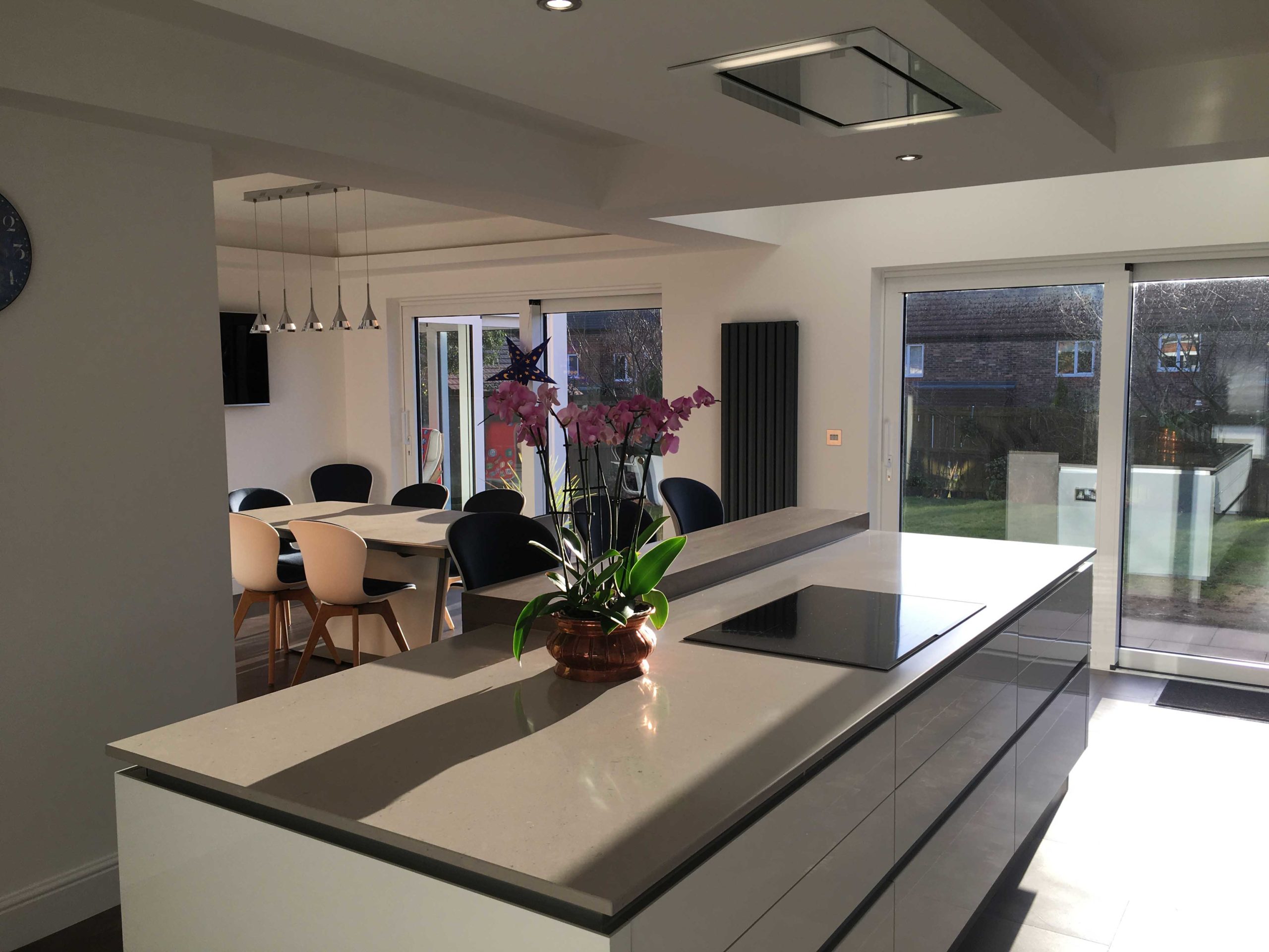 gloss white with wood accsent large breakfast island with dropped ceiling and designer ceiling hood