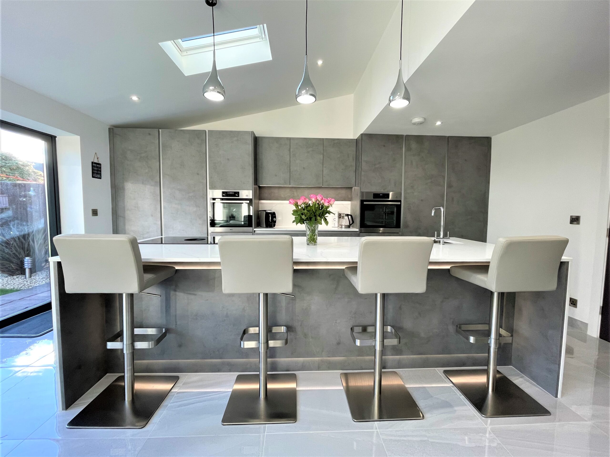 matt textured concrete breakfasting kitchen and media furniture