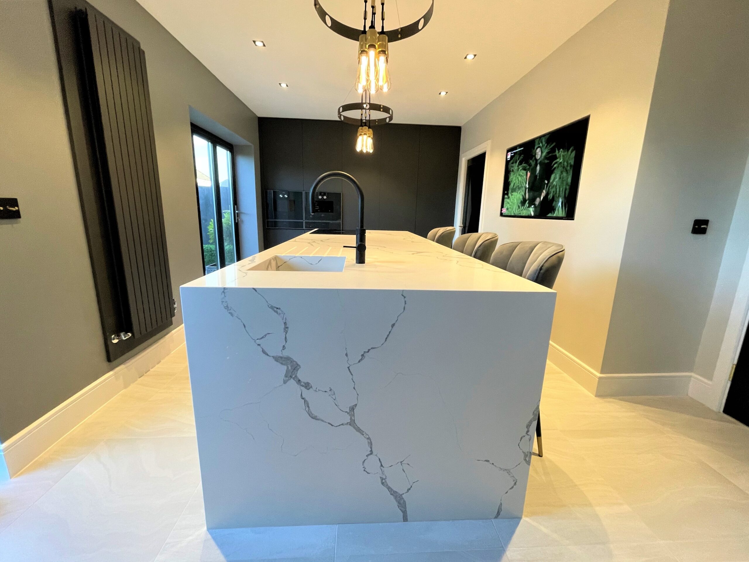 graphite satin feel breakfasting kitchen with oak accent and wall hung media furniture